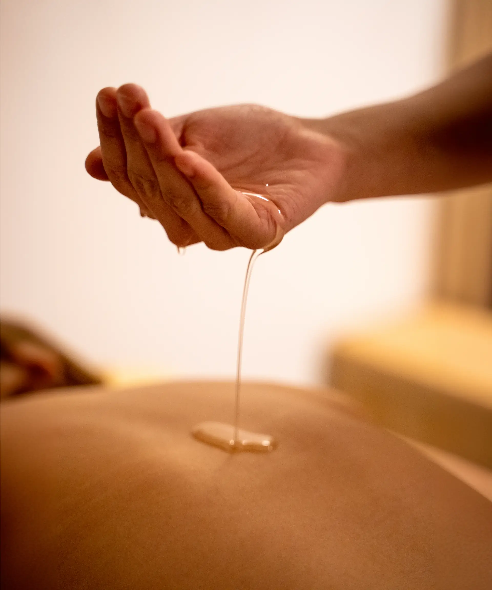 Huile de soin bio appliquée sur le corps lors d’un rituel bien-être